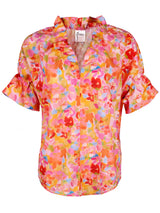 A front view of the Finley Crosby blouse, a short puff sleevd v-neck blouse with an abstract pink and orange capri floral pattern.