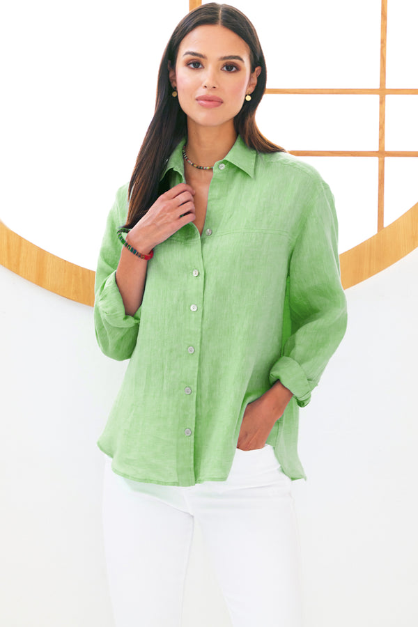 A model wearing the Finley Niko blouse, a pale green button down washed linen boyfriend shirt. 