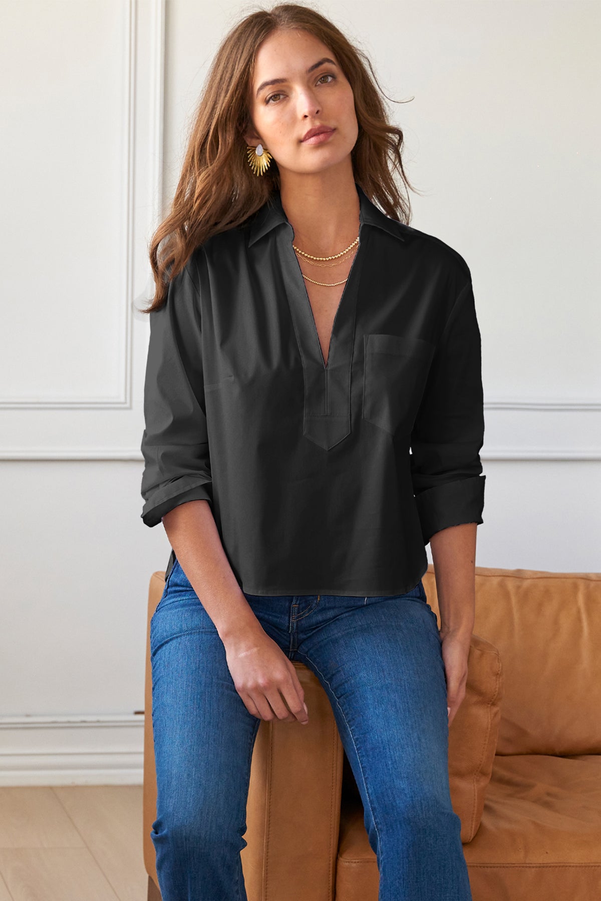 Model wears Finley Joni long sleeve poplin popover blouse with V neckline and chest pocket. Boxy fit.