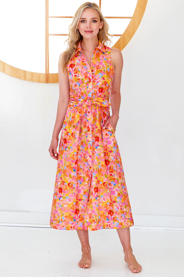 A model wearing the Finley Ellis dress, a sleeveless maxi tie front dress with a pink & orange floral print.