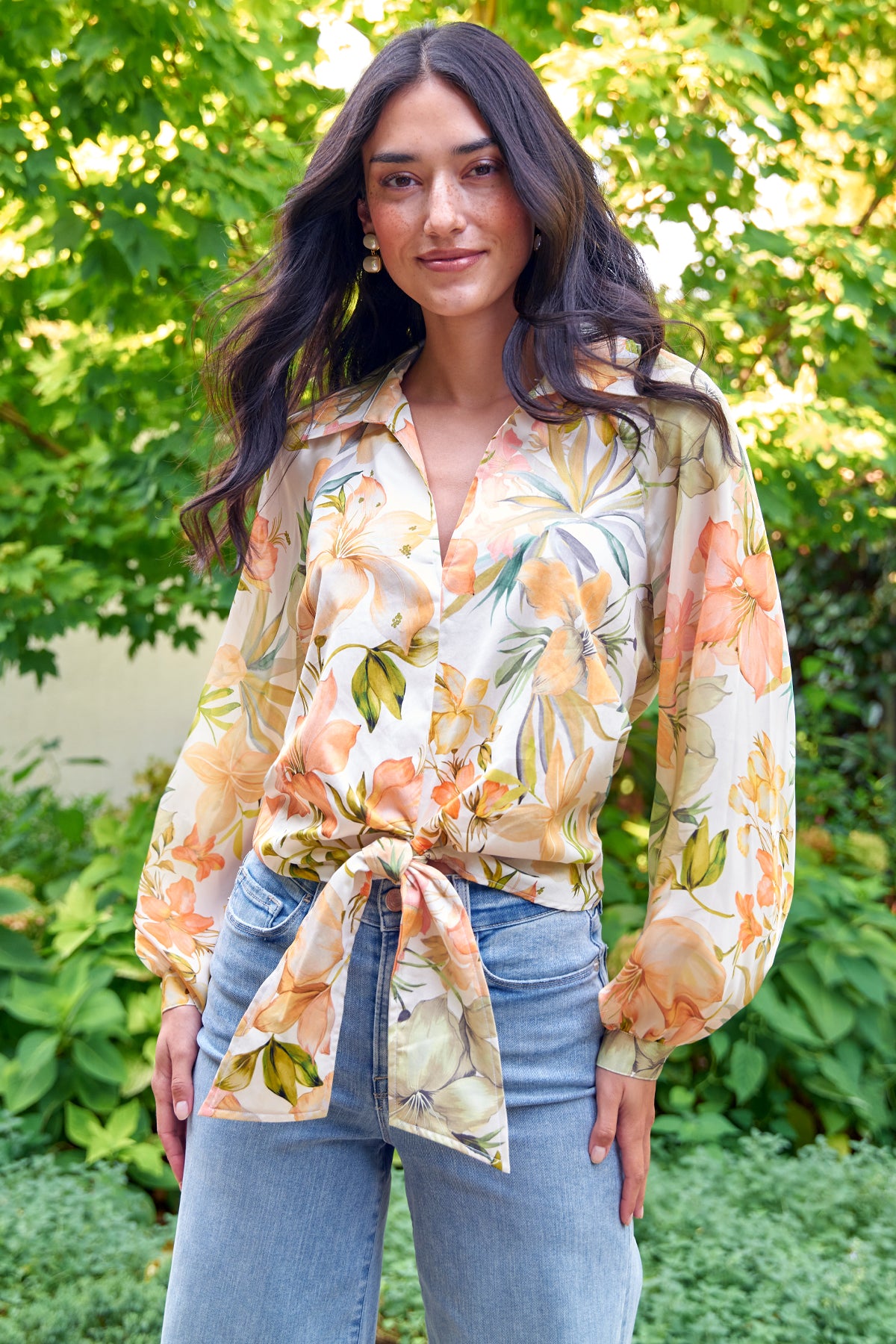 Model wears Finley Paloma floral print blouse with V-neckline and waist tie. Raglan blouson sleeves.