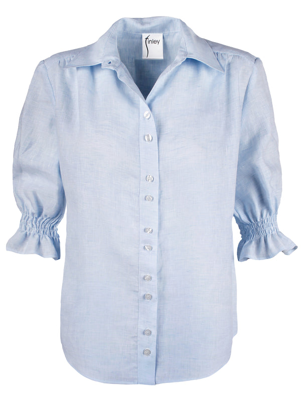 A front view of the Finley Sirena blouse, a pale blue chambray linen button down blouse with elbow-length puff sleeves.