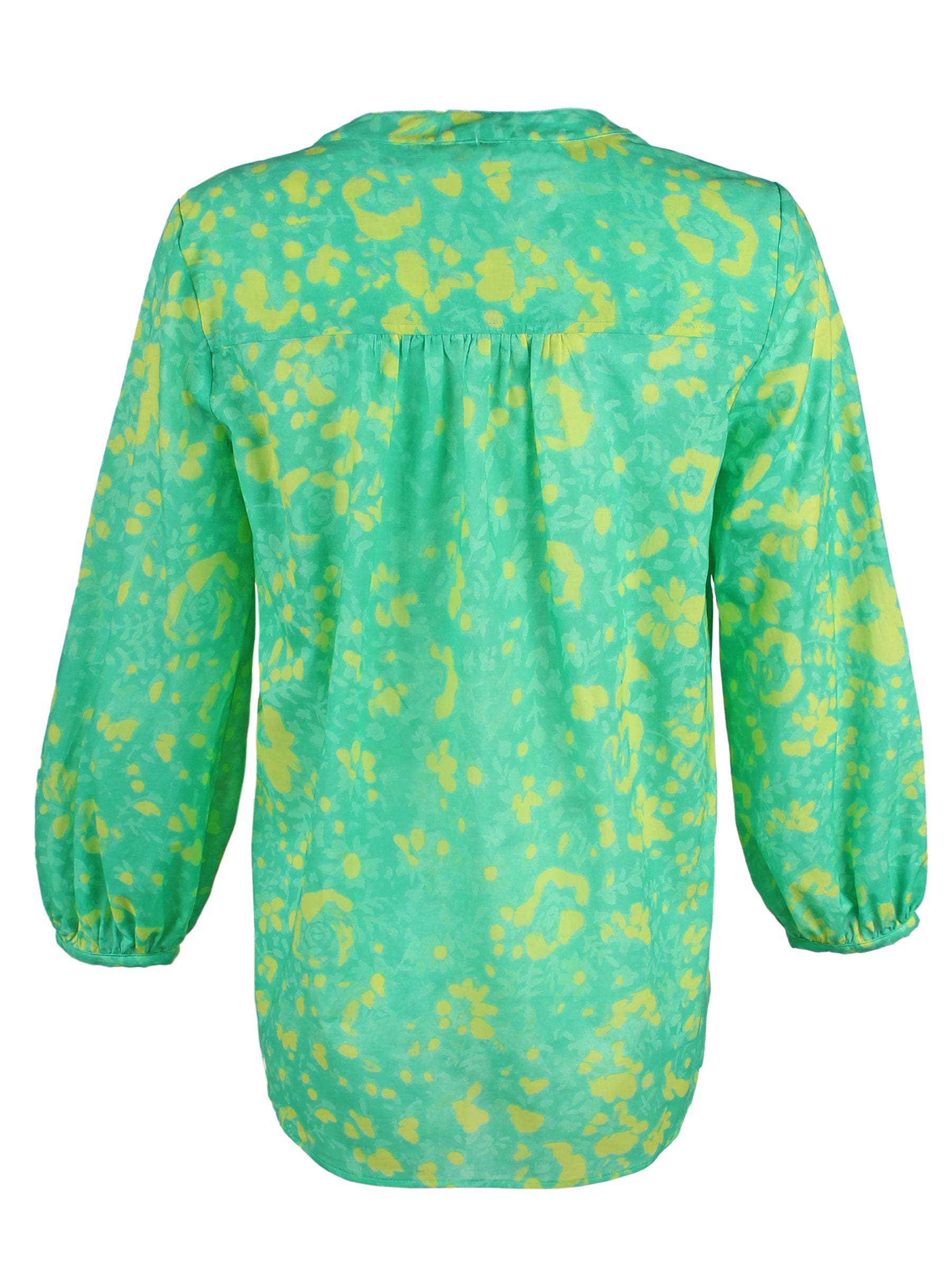 A rear view of the Finley Stephanie top, a v-neck blouse with bracelet sleeves and a bright green and yellow floral print.