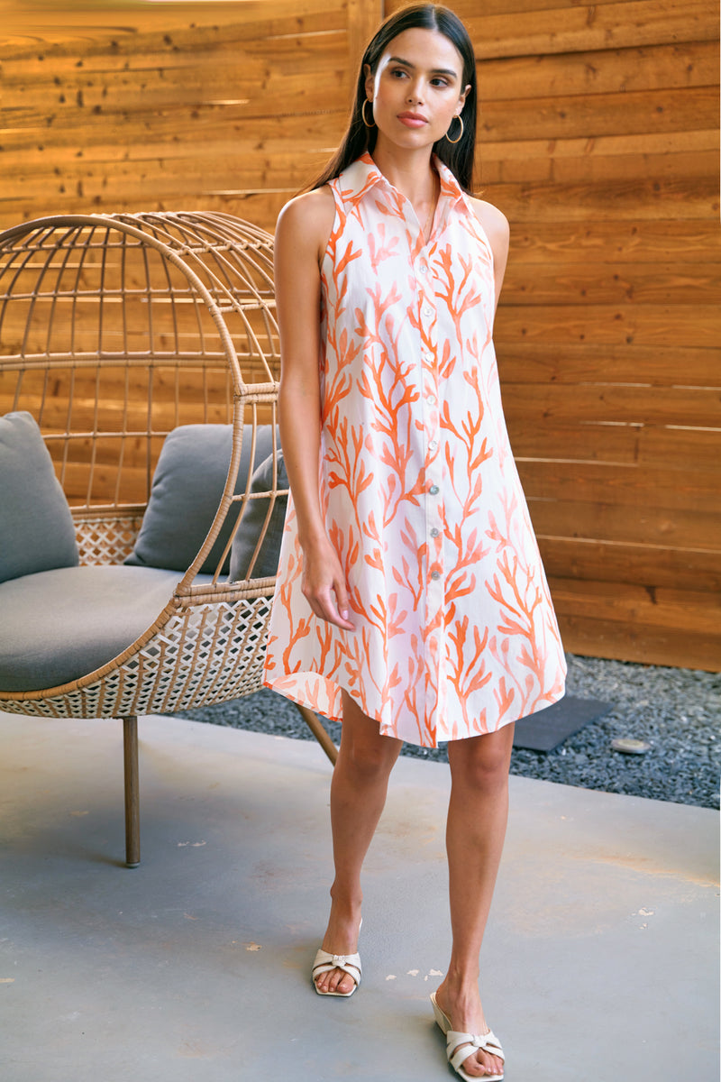 A model wearing the Finley Swing Dress, a sleeveless button-down relaxed fit maxi dress with an orange coral reef print.