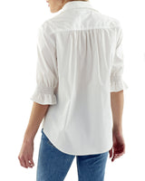 A rear view of the Finley Sirena blouse, a pale blue chambray linen button down blouse with elbow-length puff sleeves.
