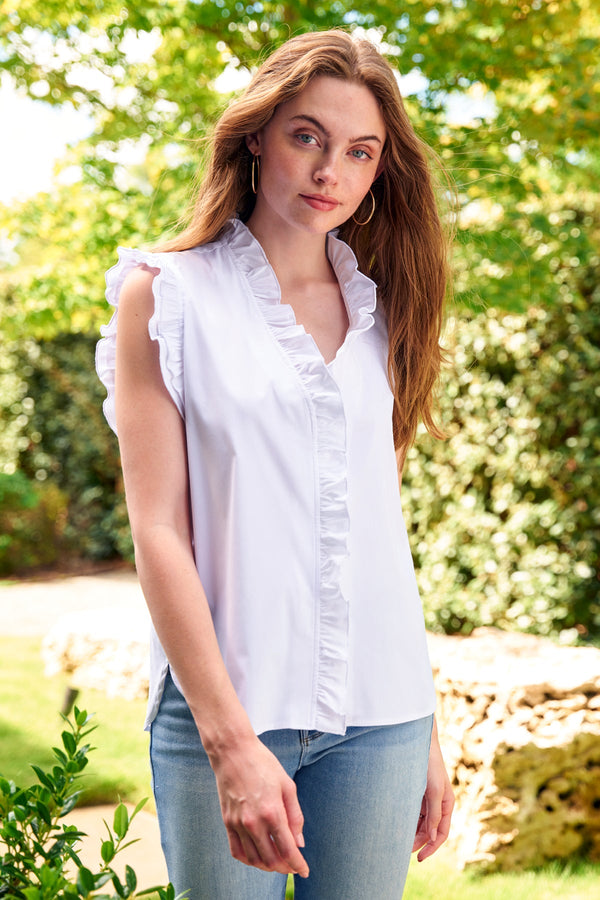A model wearing the Finley Byrdee blouse, a casual sleeveless white button-down blouse with ruffle collar and sleeve detail.