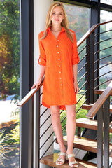 A model wearing the Finley Alex shirt dress, an orange textured jacquard shirtdress with barrel cuffs and a relaxed shape.