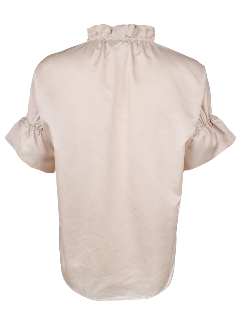 A rear view of the Finley Crosby blouse, a short sleeve cotton silk blouse with ruffle collar accents and a champagne gold color.