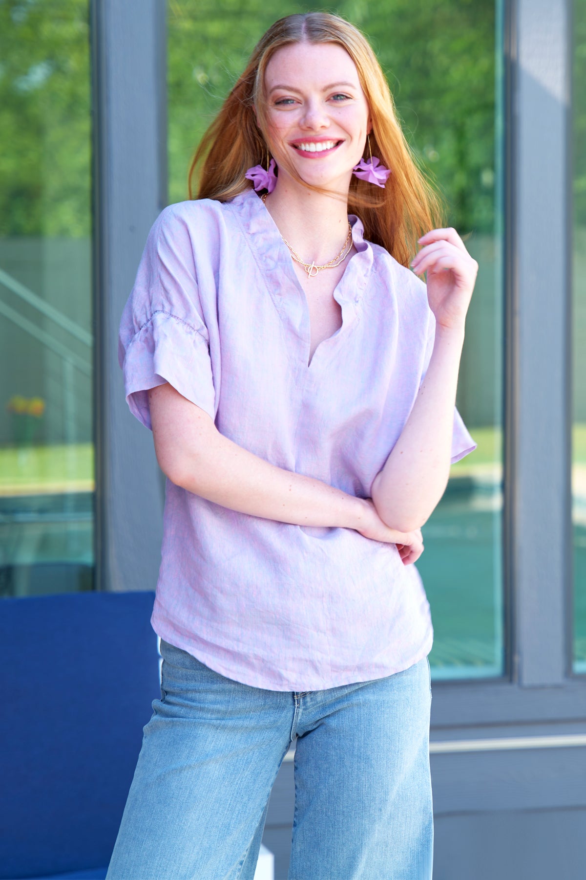 a model front view of the Finley Crosby blouse with a popover design, washed linen fabric, lilac color, and ruffle collar & sleeve detail.
