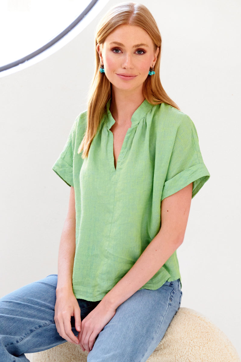 A front view of the Finley Jay blouse, a washed linen pale green popover blouse with a mandarin collar, short sleeves, a v-neckline.