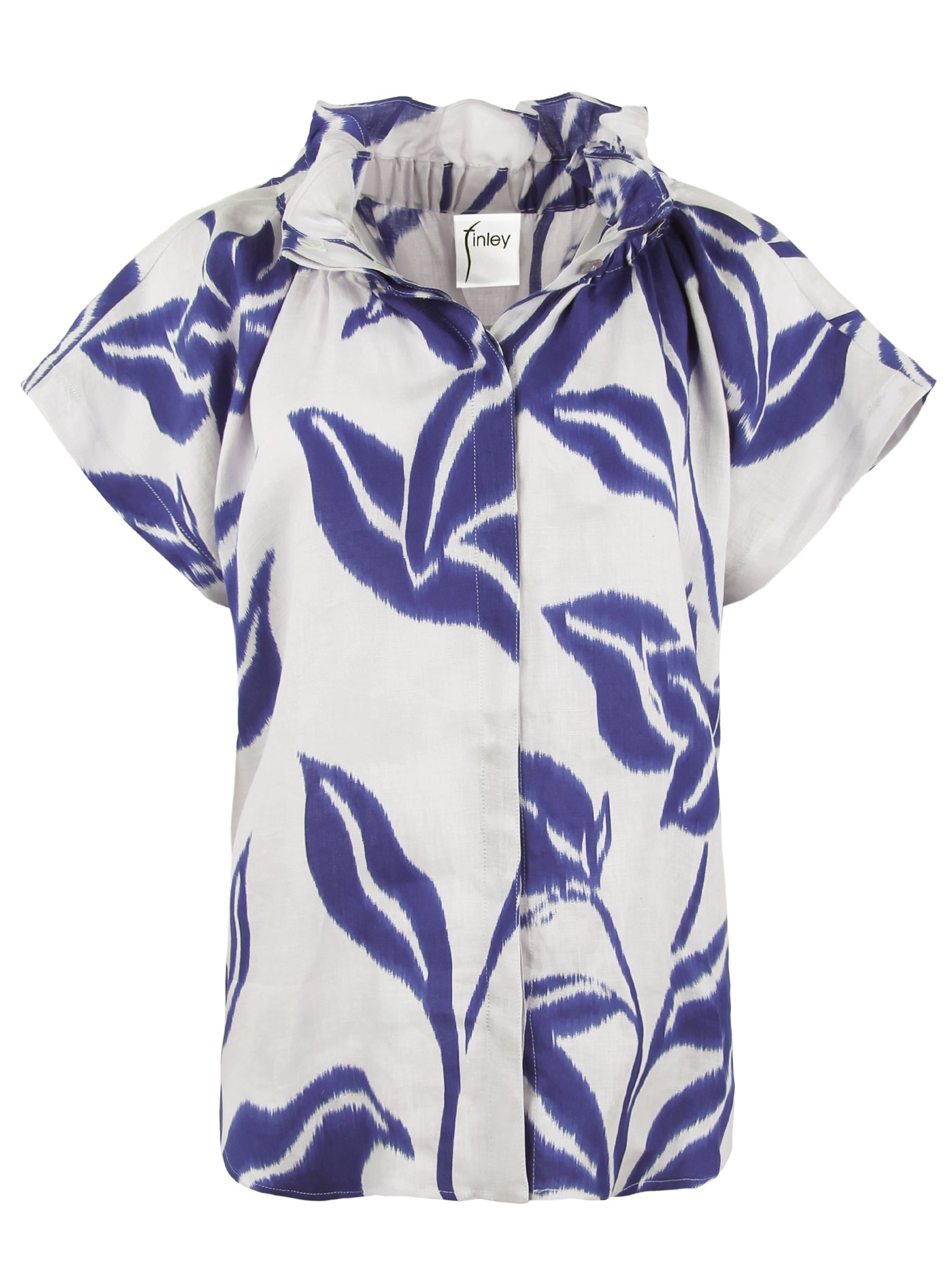 A model view of the Jenny blouse, a relaxed 100% linen piece with short sleeves, a stand collar, and a blue floral batik pattern.
