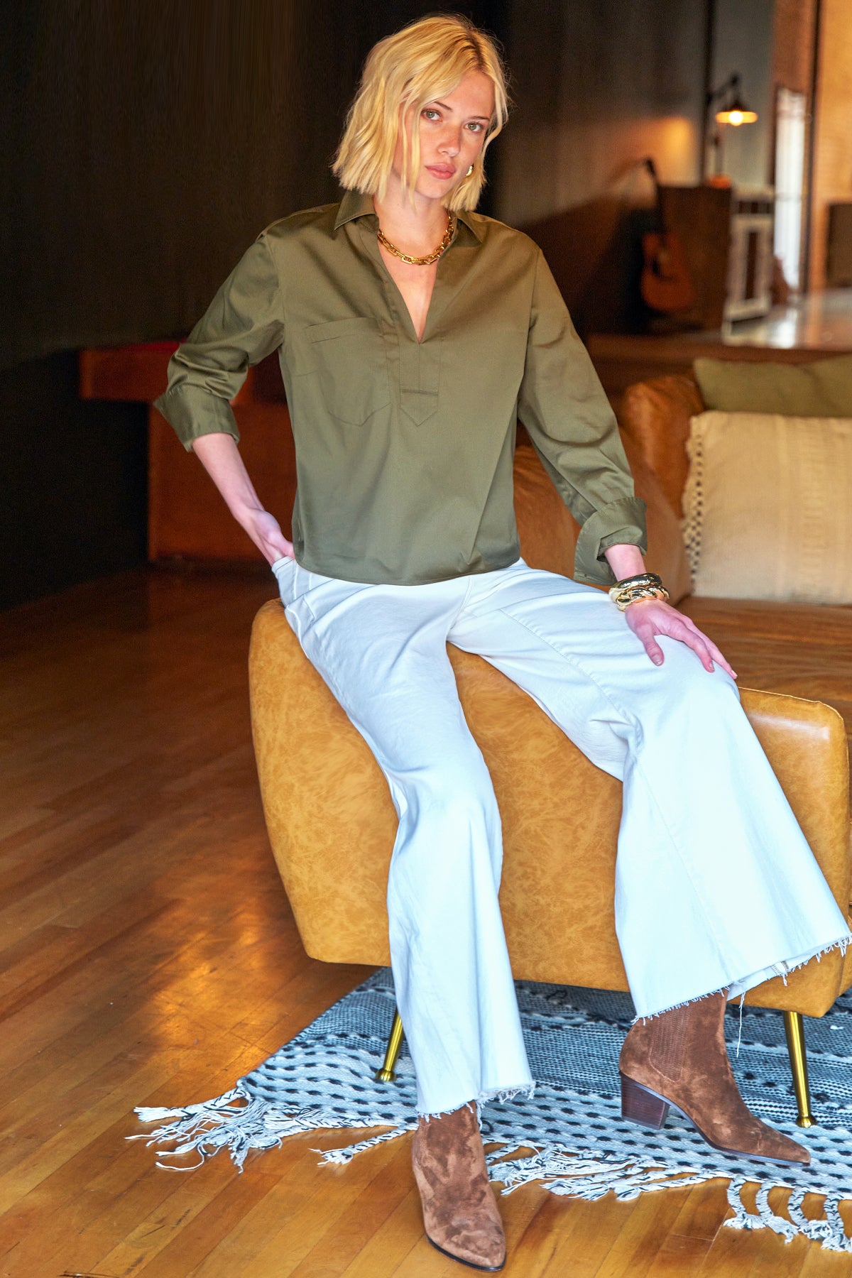 A model wearing the Finley Joni, a silky poplin olive green v-neck blouse with a relaxed contour.