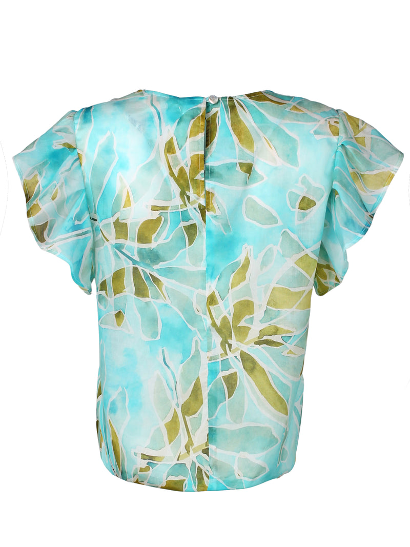 A rear view of the Finley knot top, a cotton voile popover blouse with a knotted hem and a pale blue tropical print.