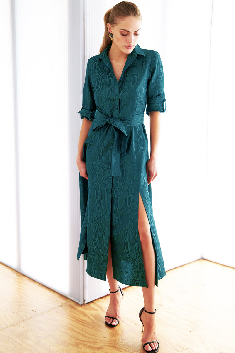 A model wearing the Finley Laine dress, a teal long sleeve tie front maxi dress with tonal moire jacquard embroidery and a self-tie belt.