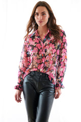 A young woman wearing the Finley Marianne blouse, a red and black floral print button down designer blouse with a tailored fit.
