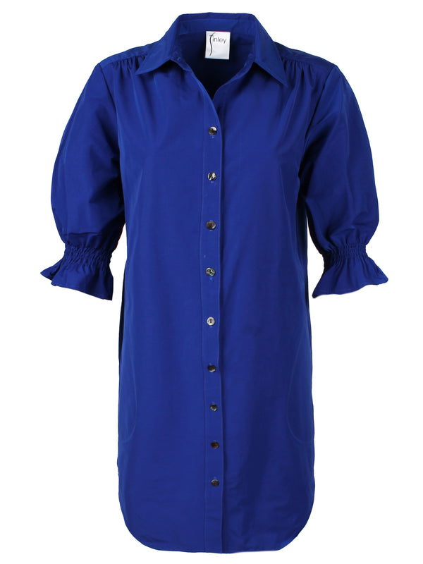 A front view of the Finley Miller shirt dress, a royal blue cotton/poly shirt dress with puff short sleeves, pockets, and a relaxed shape.