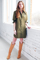 A fashion model wearing the Miller dress, a button down olive designer shirtdress with a spread collar and elastic puff sleeve detail.
