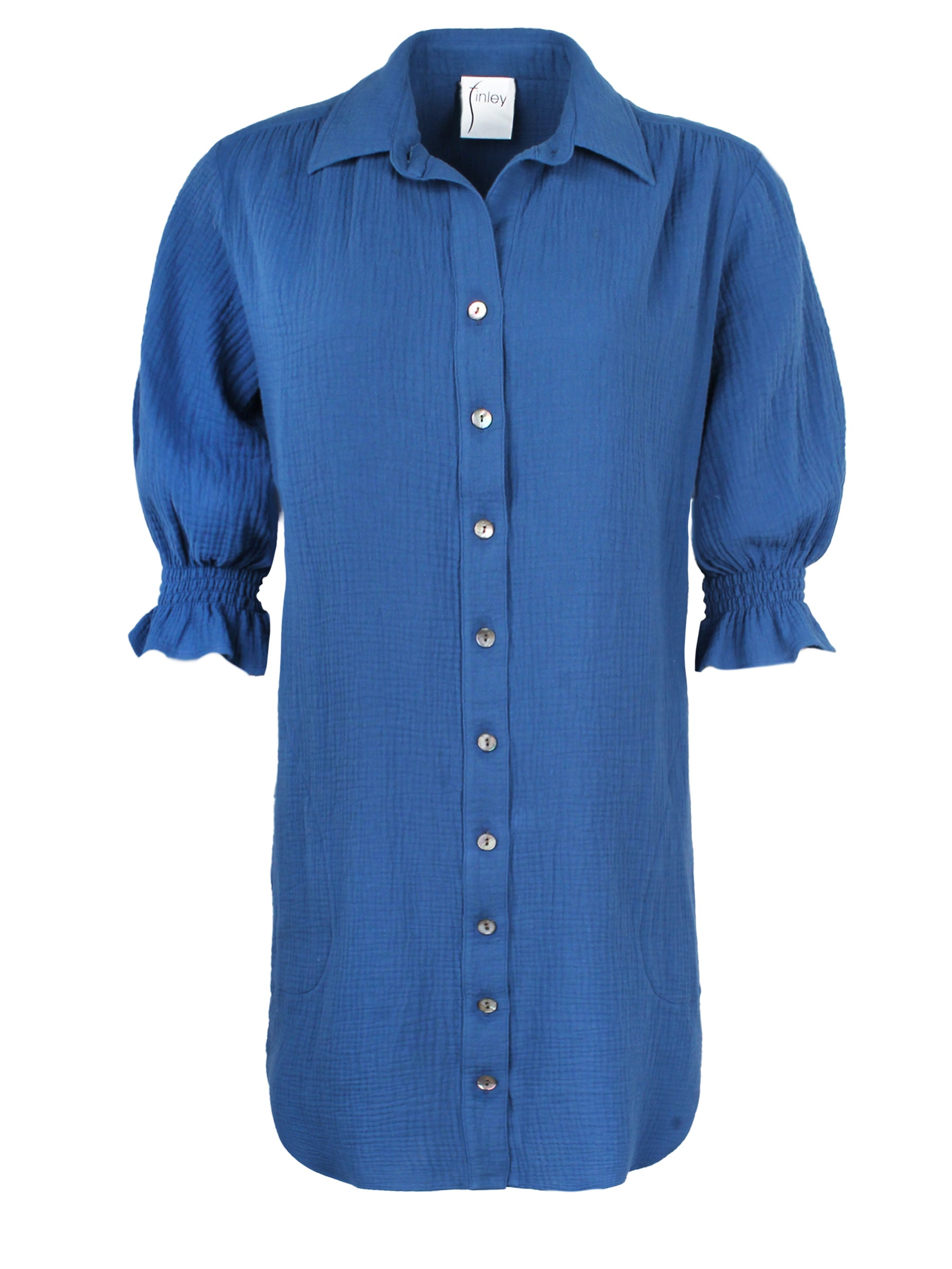 A front view of the Finley Miller shirt dress, a 100% cotton blue shirt dress with a relaxed contour and elbow-length puff sleeves.