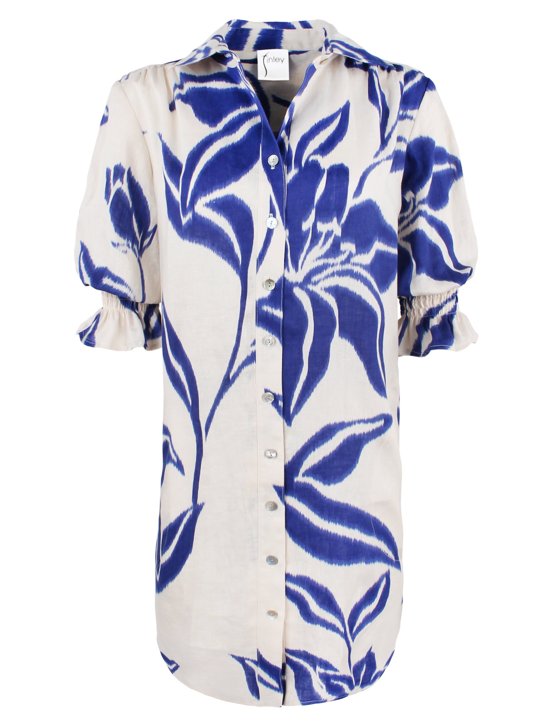 A front view of the Miller shirt dress, crafted from 100% linen with puff sleeves, a shirred shoulder, and a blue floral batik design.
