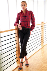 A model wearing the Finley Mystie blouse, a purple plaid button down long sleeve women's blouse with a ruffle collar and a relaxed shape.