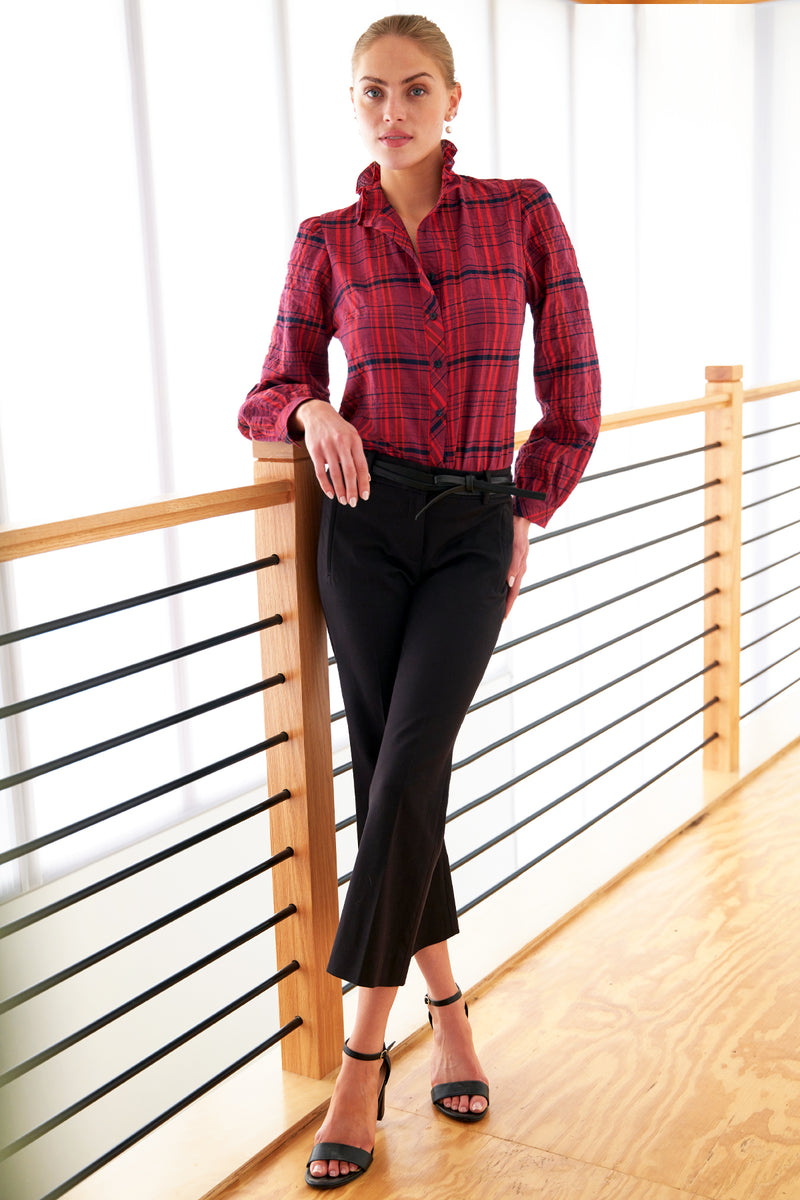 A model wearing the Finley Mystie blouse, a purple plaid button down long sleeve women's blouse with a ruffle collar and a relaxed shape.