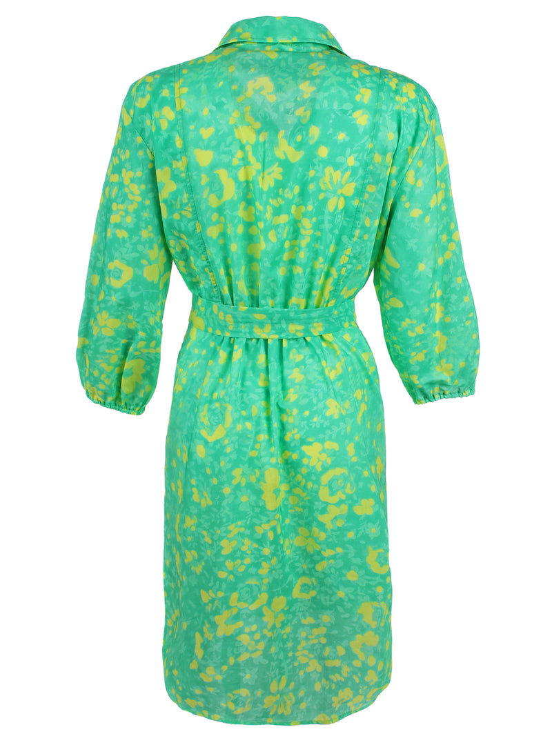 A rear view of the Finley Natalie shirt dress, a tie-front shirt dress with a semi-fitted shape and a bright green and yellow floral print.