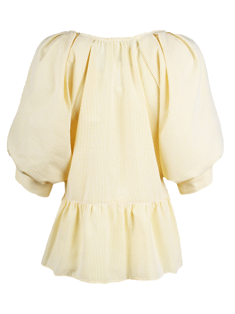 The Finley Prisha blouse, a yellow seersucker popover v-neck blouse with puff short sleeves and a flounce ruffle hem.