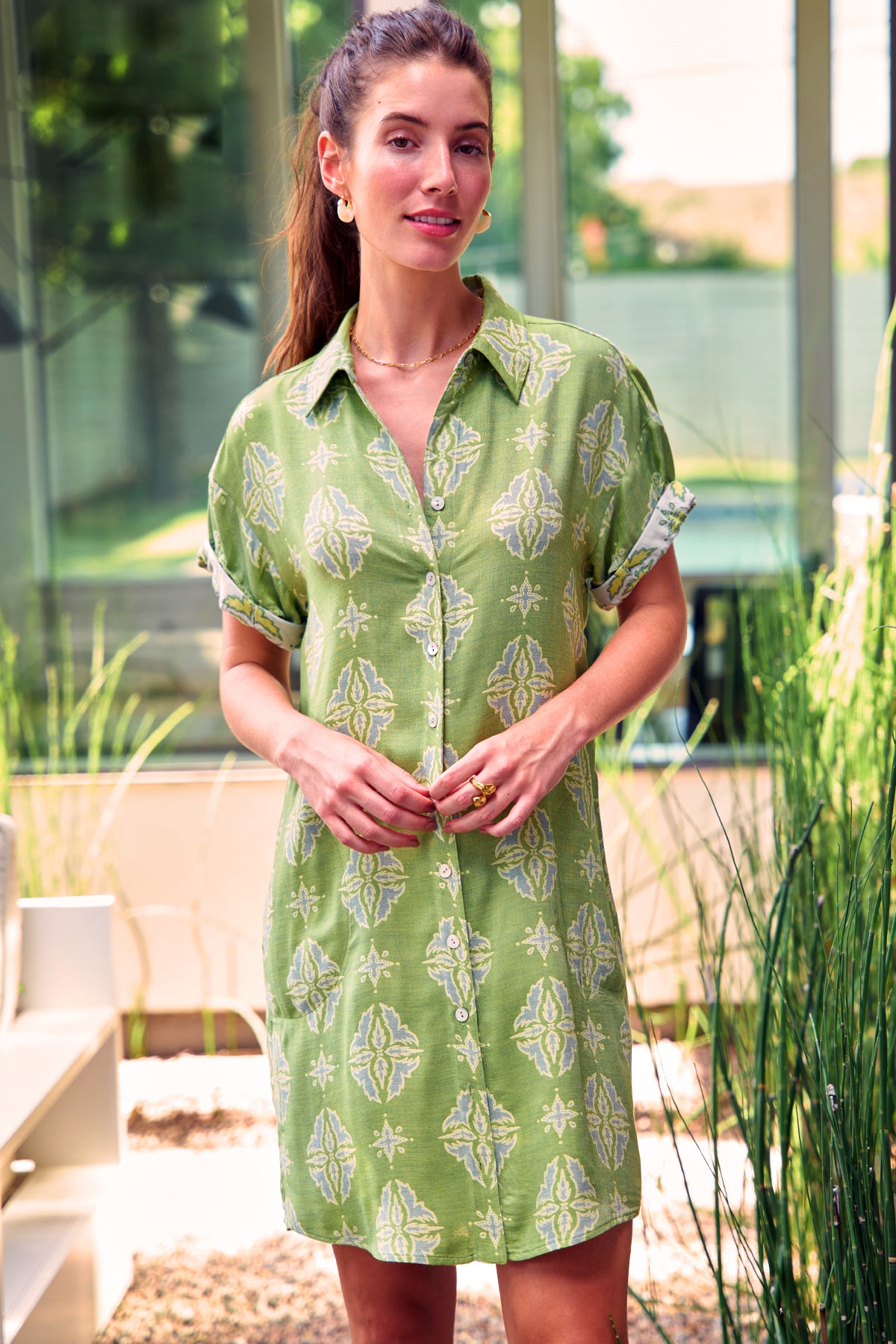 Model wears Finley Roll Sleeve Camp Shirt Dress in green and yellow jacquard. Button front, above-knee length.
