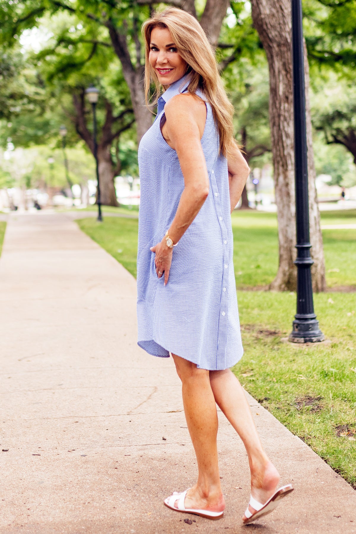A super model wears the Finley swing dress, a red & white seersucker sleeveless shirt dress with an A-line silhouette.