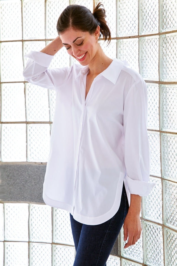 A supermodel wearing the Finley Sylvie blouse, a white poplin blouse with a self-tie cutout back and a relaxed shape.