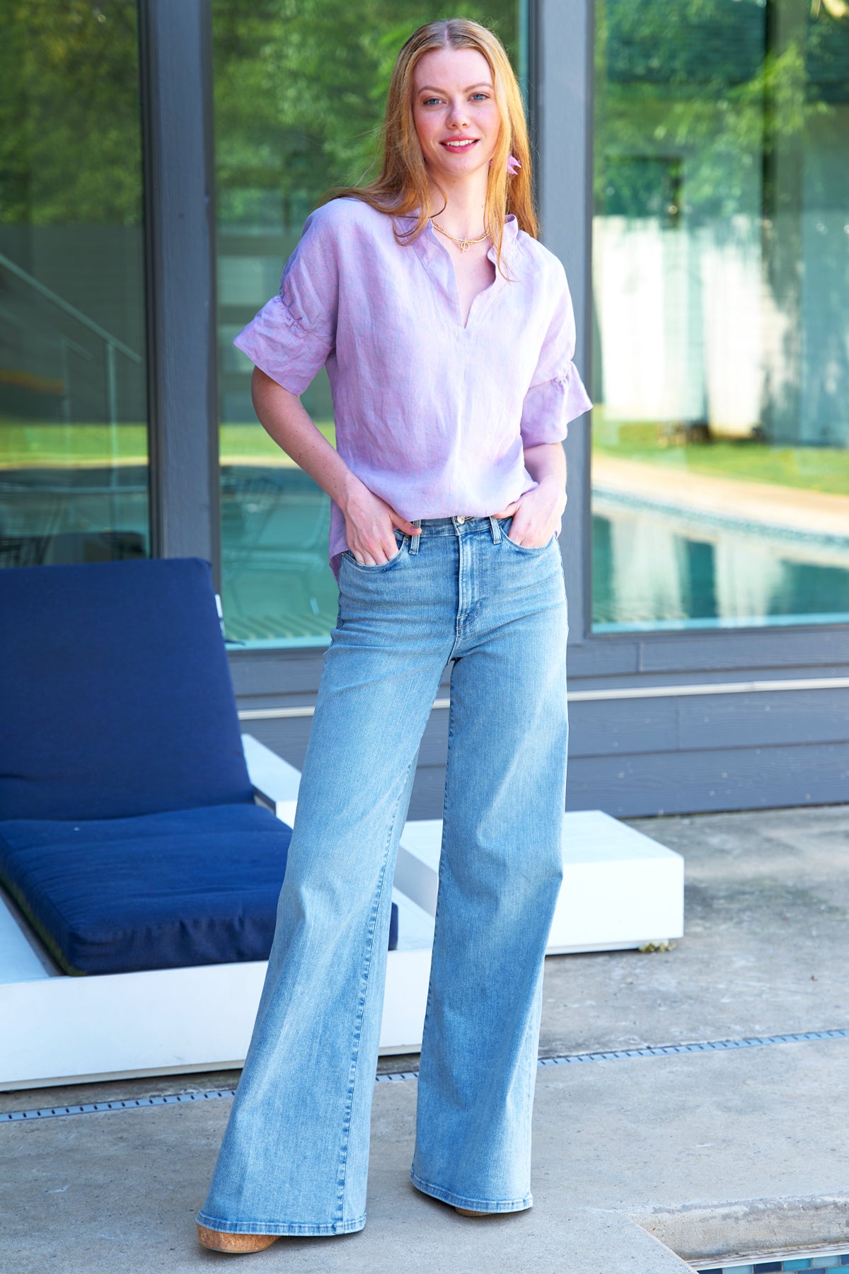 a back view of the Finley Crosby blouse with a popover design, washed linen fabric, lilac color, and ruffle collar & sleeve detail.
