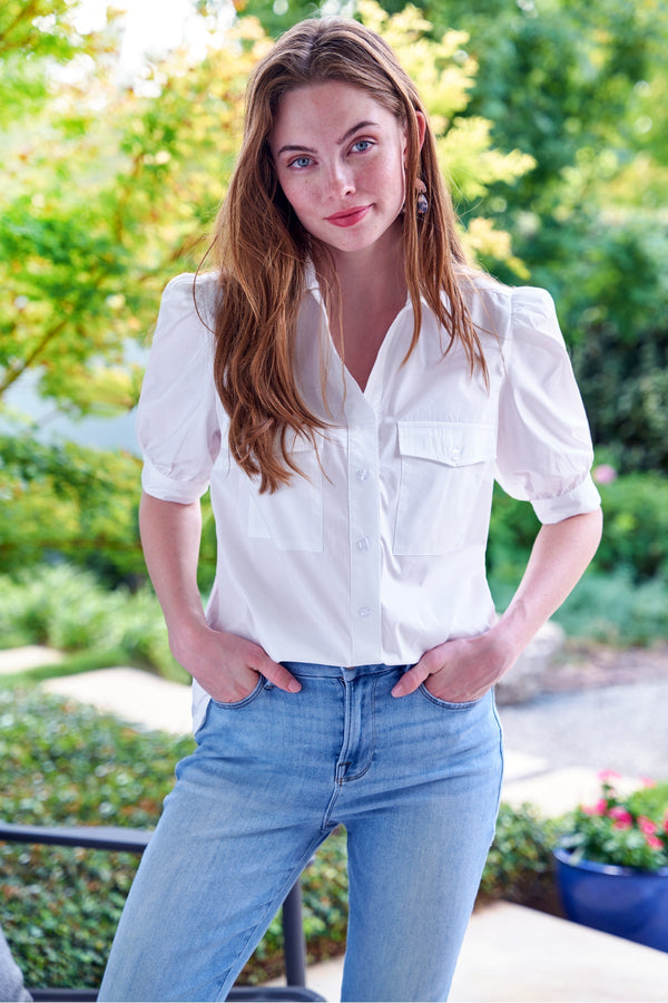 The Finley camp shirt, a white button down weathercloth blouse with chest pockets, short puff sleeves, and a relaxed fit.