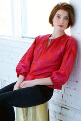 The Finley crew top, a pink and red polyester pullover blouse with a 3/4 sleeve and a pink and red floral jacquard pattern.