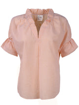 Front view of the Crosby blouse, a casual popover women's shirt with ruffle detailing and an orange and white seersucker pattern.