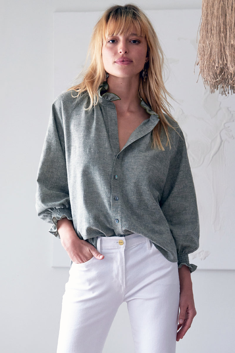 The Finley Fiona shirt, a washed hemp sage green chambray button down blouse with ruffle detailing on collar and sleeves.