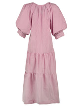 The Finley Paloma dress, a pink and white seersucker maxi dress with pleated blouson sleeves and a ruffle hem.