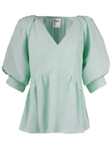 The Finley Prisha blouse, a green seersucker popover v-neck blouse with puff short sleeves and a flounce ruffle hem.