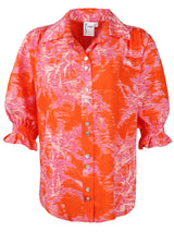 The Finley Sirena shirt, a shortsleeve button-down blouse with puff sleeves and a bright orange and pink floral print.
