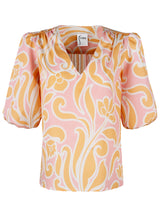 The Finley Tish top, a 100% cotton v-neck popover blouse with short puff sleeves and an orange floral pattern.