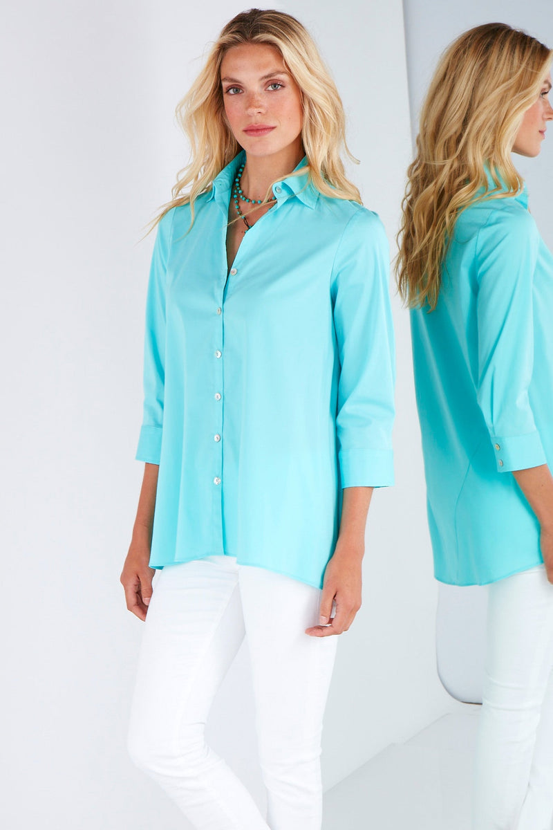 A fashion model wearing the Finley trapeze top, a black long-sleeve button-down blouse with a relaxed fit and an A-line shape.