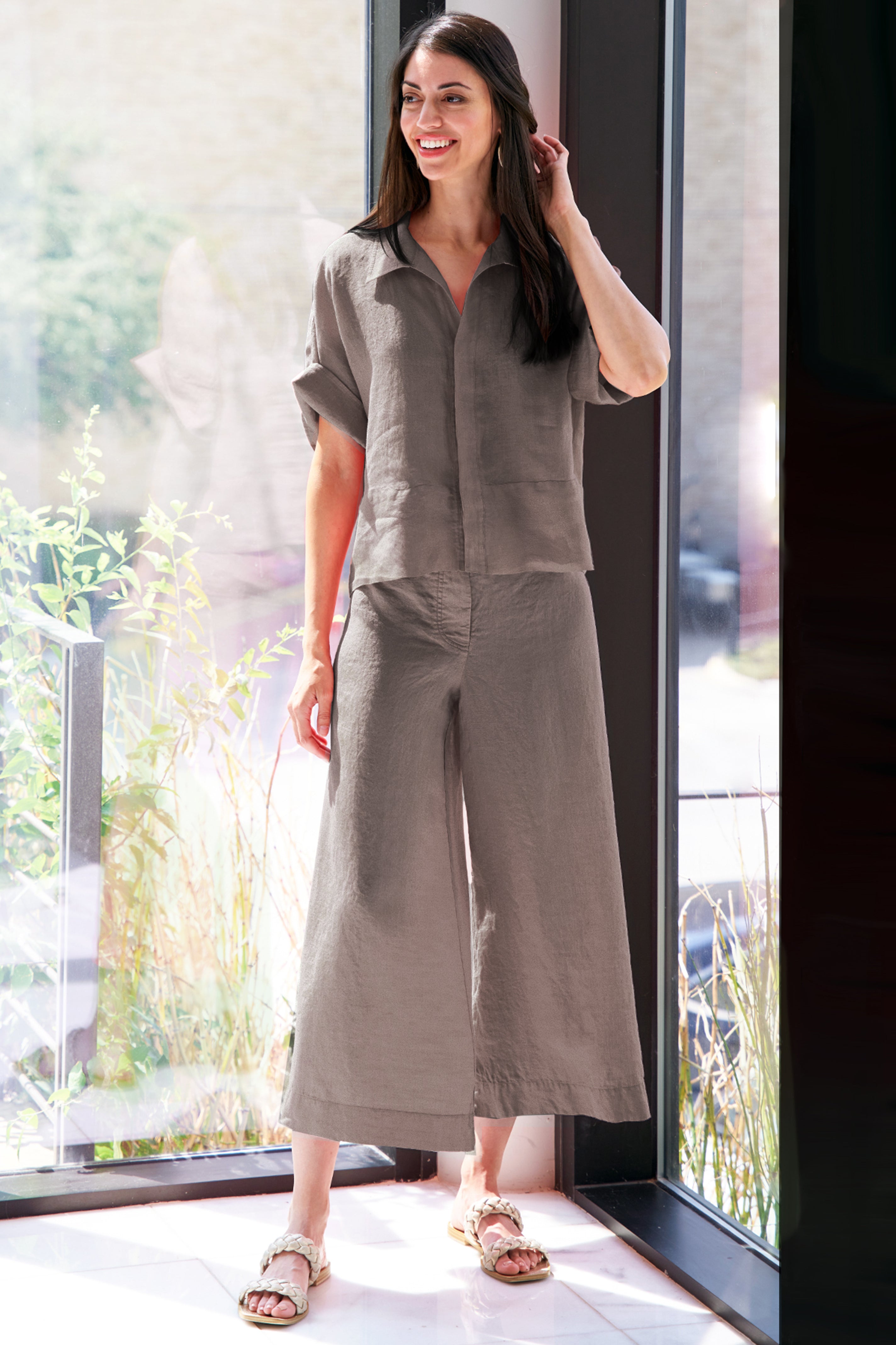 A model wearing the Wide Leg washed linen pants, featuring drawstring details, side pockets, and a relaxed fit in mushroom brown.
