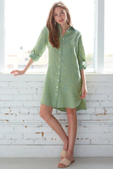 A fashion model wearing the Finley Alex dress, a peach pink washed linen button-down shirt dress with tabbed sleeves and relaxed fit.
