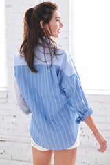 A model wearing the Finley boyfriend shirt, a color-blocked blue and white striped shirt with an asymmetric pocket.