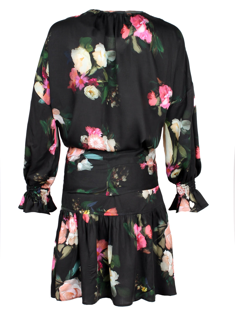 A rear view of the Finley Coco dress, a midi peasant dress with a long sleeves, a front tie and a Dutch floral pattern.