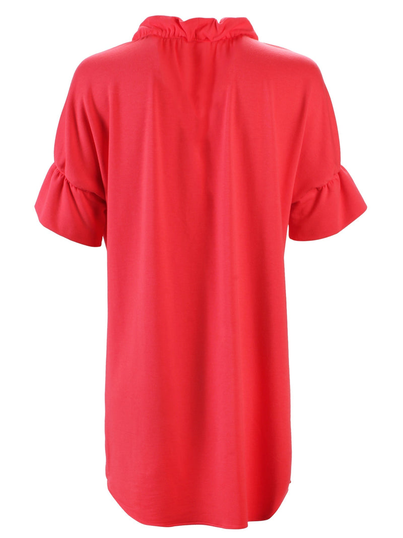 A rear view of the Finley Crosby shirt dress, a washed linen dress with ruffled sleeves and collar and a coral pink color.