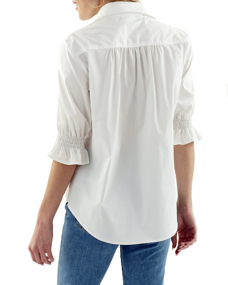 A rear view of the Finley Sirena blouse, a button-down washed linen blouse with puffed short sleeves and avocado green color.