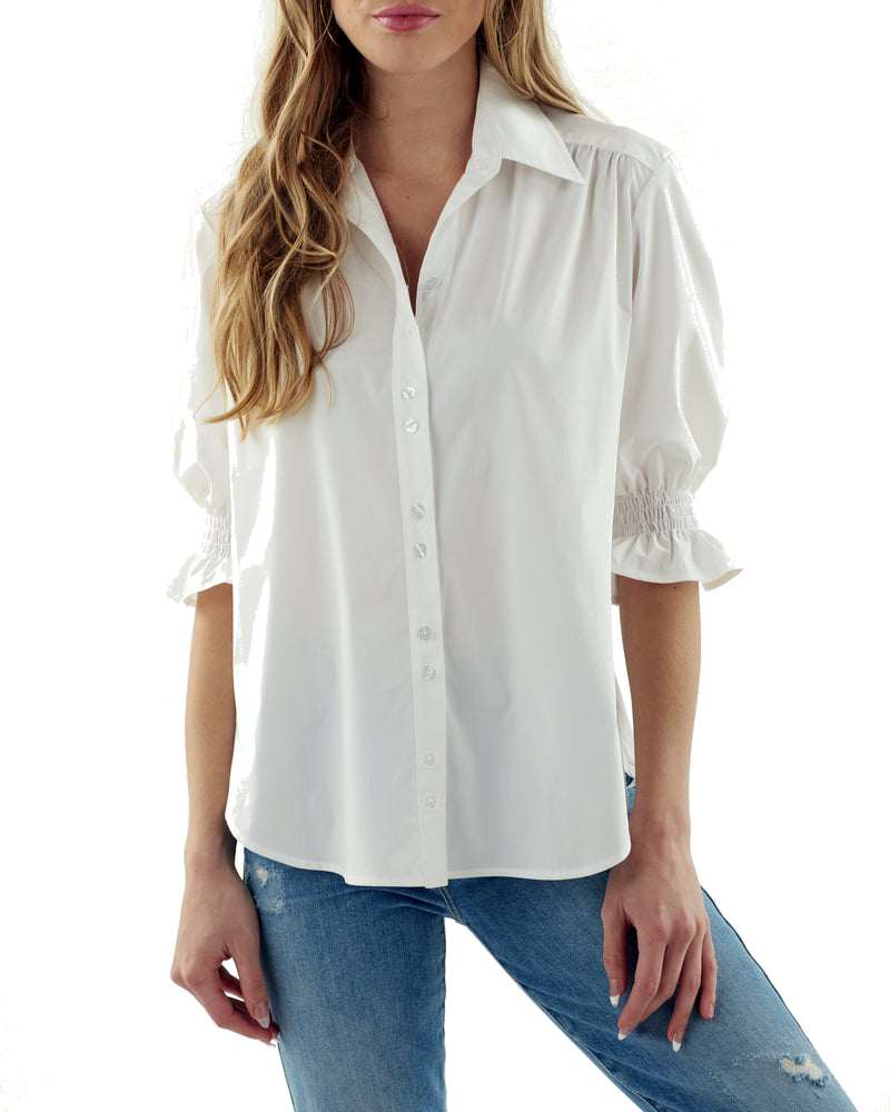 A model wearing the Finley Sirena shirt, a blue and white striped button-down blouse with a puffed sleeve and spread collar.