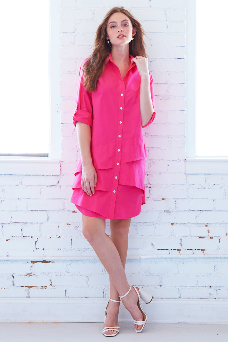 A blonde female model wearing Finley Jenna dress, a bright pink cotton shirtdress with bias flounces accents