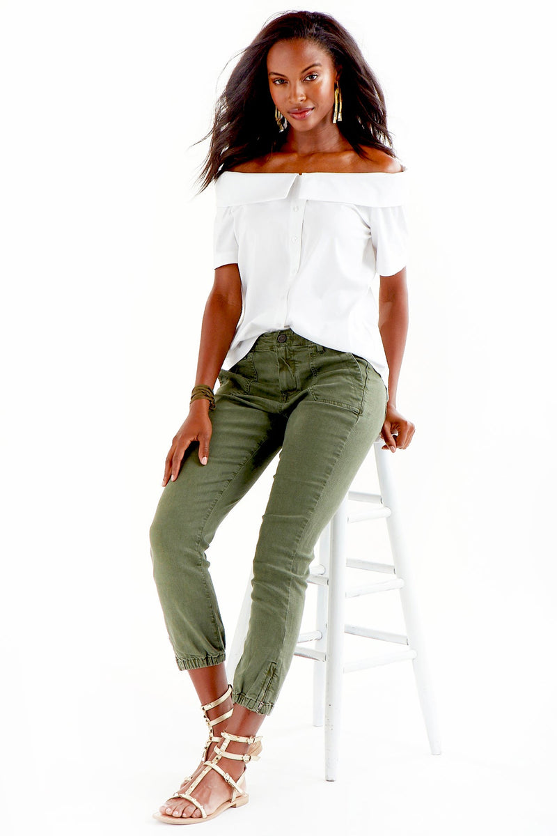 A model wearing the Finley Maddie top, an off the shoulder blue button-down blouse with short sleeves and black and white stripes.