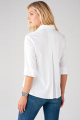A blonde fashion model wearing the Finley Swing Shirt, a white 3/4 sleeve blouse with a turnback collar.